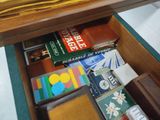 a drawer full of books and other items on the table