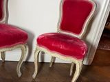 two red chairs sitting next to each other on a wooden floor
