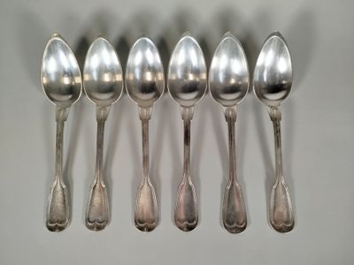 six cuillères en argent sont alignées sur une table