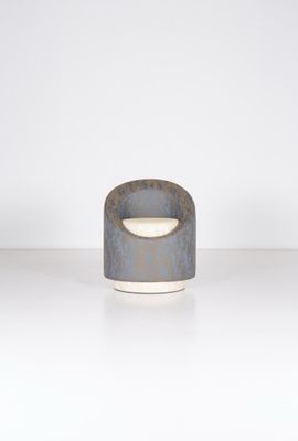 un gros plan d'un petit bol gris et blanc posé sur une surface blanche