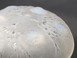 a frosted glass vase sitting on a black surface