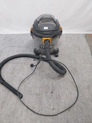 un aspirateur posé par terre, avec son cordon d'alimentation