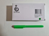 a green pen next to a white box with a barcode on it