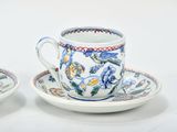 two cups and saucers sitting on a white table