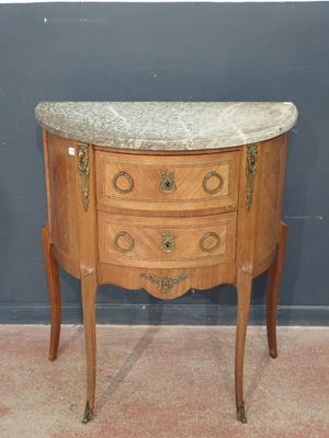 a small marble top chest of drawers on a stand