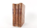 two old books sitting on top of each other on a white surface