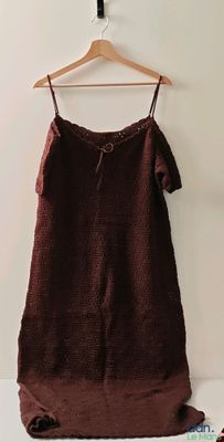 une robe marron suspendue à un cintre à côté d'une brosse à dents