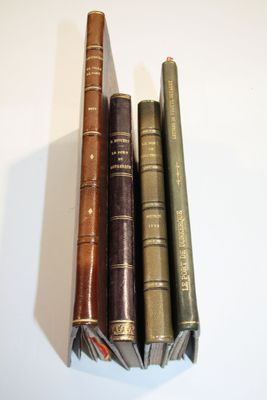 trois vieux livres sont empilés sur une table