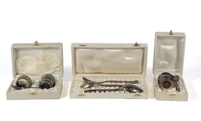 three silverware items are in a white box on a white surface