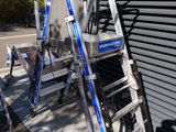 two ladders that are leaning against a building