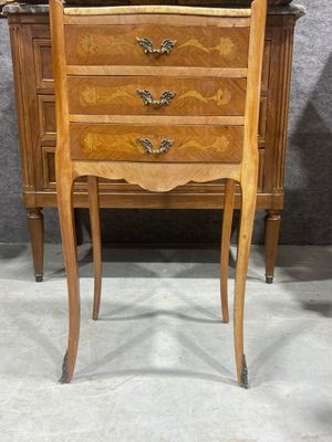 une petite commode en bois exposée dans une pièce