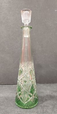 a green glass bottle that is sitting on a table