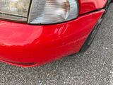 a close up of a red car with its headlights turned on