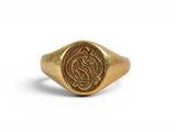 Gros plan sur une bague en or ornée d'une pièce de monnaie