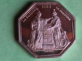 a silver coin with a picture of a man and woman on it