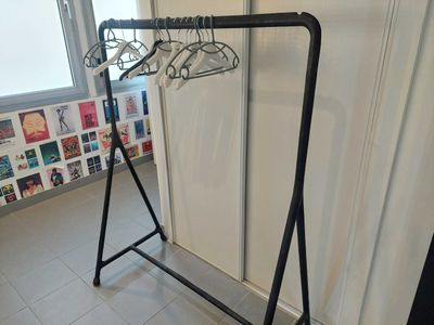 a rack with clothes hanging on it in a room
