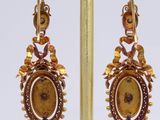 pair of earrings with a picture of a woman and a bird