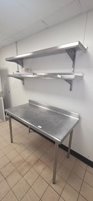 a large stainless steel table in the middle of a kitchen