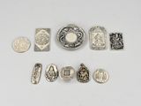 several silver metal objects including a coin, a coin, and other items