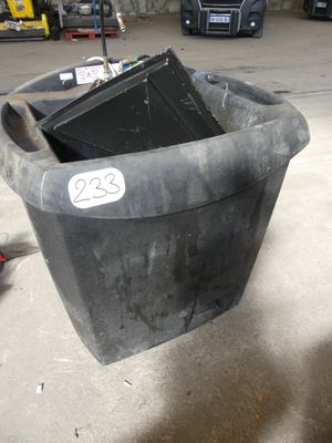 une poubelle noire portant un numéro, dans un garage
