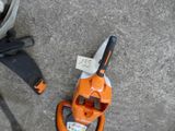 an orange and black leaf blower and a black and white bag