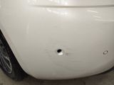 a white car with a hole in the front of it