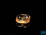 un diamant jaune sur une surface noire