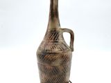a brown vase that is sitting on a white surface