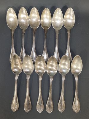 six silver spoons are arranged in a row on a black surface