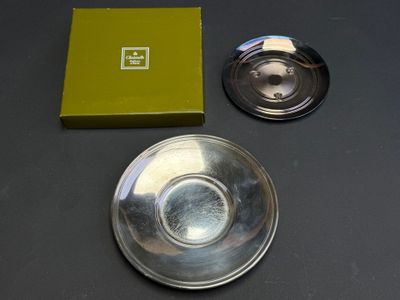 a silver plate and a green box on a table