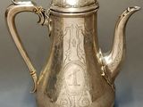an antique silver tea pot with a handle and a lid
