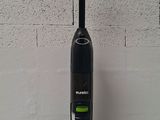 a close up of a vacuum cleaner on a table with a brick wall in the background