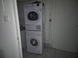 une machine à laver et un sèche-linge empilés l'un sur l'autre dans une petite pièce