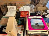 a pile of books on a table with a brick wall in the background