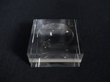 a small glass object on a black surface
