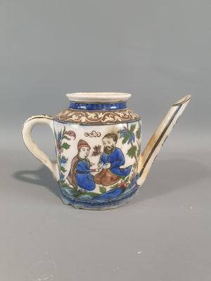 théière bleue et blanche ornée d'un motif représentant un homme et une femme