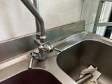 a kitchen sink with a metal faucet next to a window