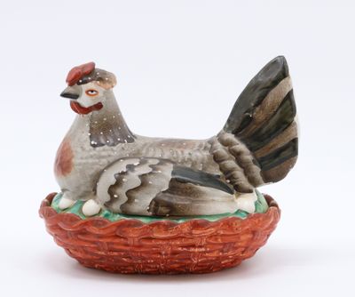 Boîte en faïence polychrome figurant une poule couvant ses œ…