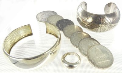 a silver ring and a silver cuff with a coin on it