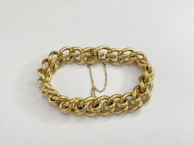 a close up of a gold chain bracelet on a white surface