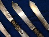 several knives are lined up on a blue surface with a blue background