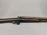 a rifle with a wooden barrel and a brass handle