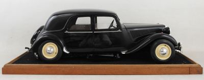 une maquette de voiture noire posée sur un socle en bois