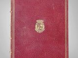 un livre rouge orné d'un emblème doré sur la couverture