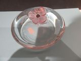 a glass bowl with a flower in it on a table
