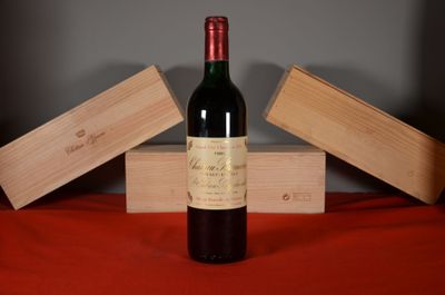 a bottle of wine sitting on a table next to two wooden boxes