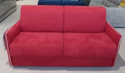 deux canapés, un rouge et un bleu, dans un salon où se trouvent d'autres meubles