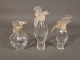 three clear glass vases with flowers on them on a gray surface