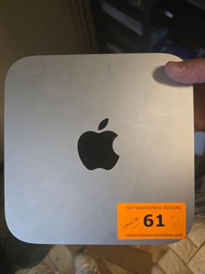 Quelqu'un tient dans ses mains un Mac mini d'Apple sur lequel est collé un autocollant.