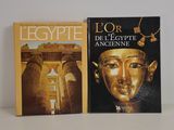 two books on a table with a white background and a black and gold cover